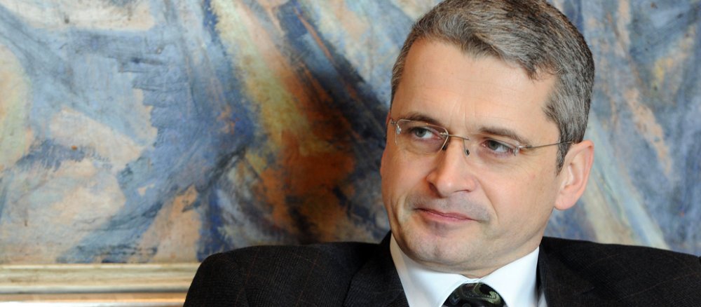 Valentin sitzt vor einem Gemälde.