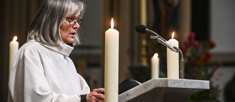 Eine Lektorin in liturgischer Kleidung liest die Lesung am Ambo