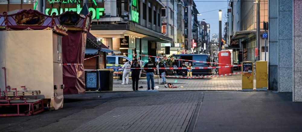 Einsatzkräfte der Polizei hinter einem Absperrband am Abend des 3. März 2025 nach einer Amokfahrt am Paradeplatz in Mannheim
