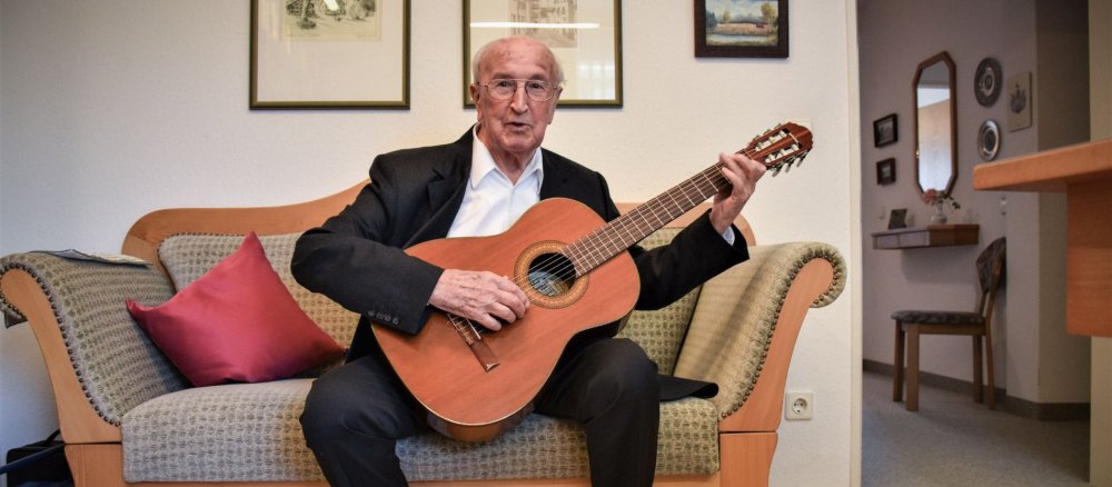 Priester Max Knorr spielt Gitarre