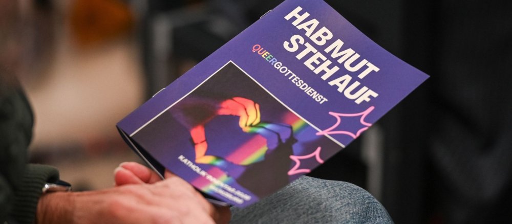 Hände mit Programmheft beim Gottesdienst zu "Das Leben ist bunt - Vielfalt in der Kirche?!"