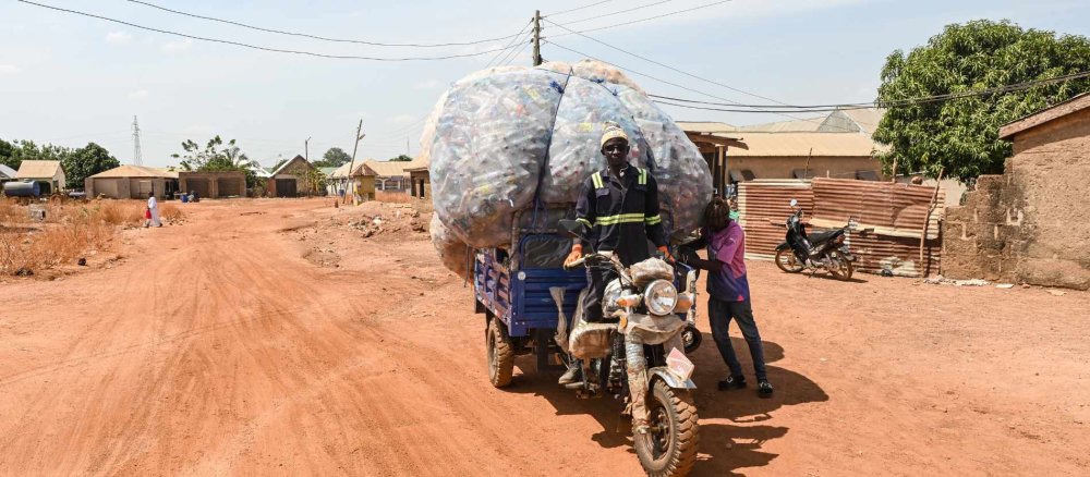 Yaro Seidu auf seinem Lastenmotorrad mit Plastikflaschen, am 26. März 2026 auf einer Sandpiste in Tamale (Ghana).
