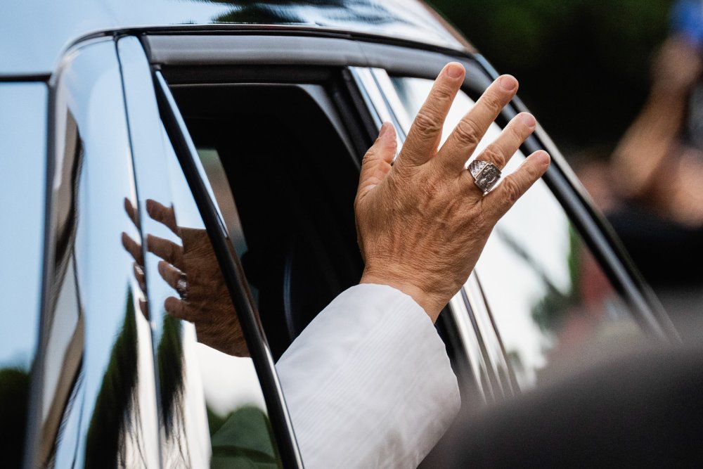 Die Hand von Papst Leo XIV. winkt aus einem geöffneten Auto-Fenster