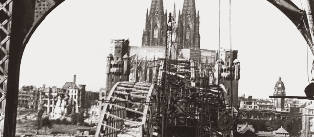 Der Dom steht noch, aber die Rheinbrücke und viele Gebäude sind am Ende des Zweiten Weltkrieges zerstört.