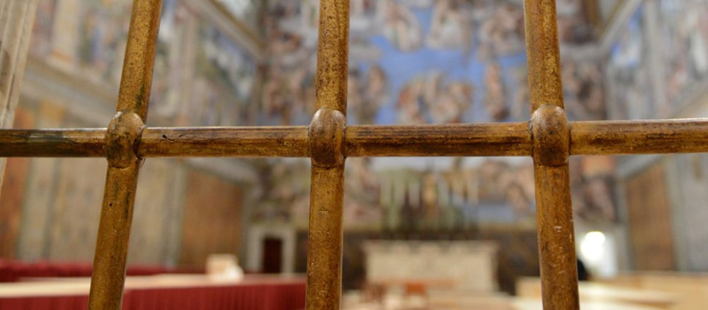 Blick durch ein Gitter in die Sixtinische Kapelle.