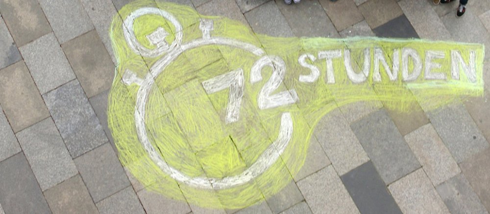 Ein Kreidebild des Logos des 72-Stunden-Aktion vor dem Kölner Dom.