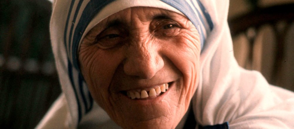 Ein Portrait von Mutter Teresa (1910-1997), alt lächelnd und mit ihrem weiß-blauen Ordensgewand.
