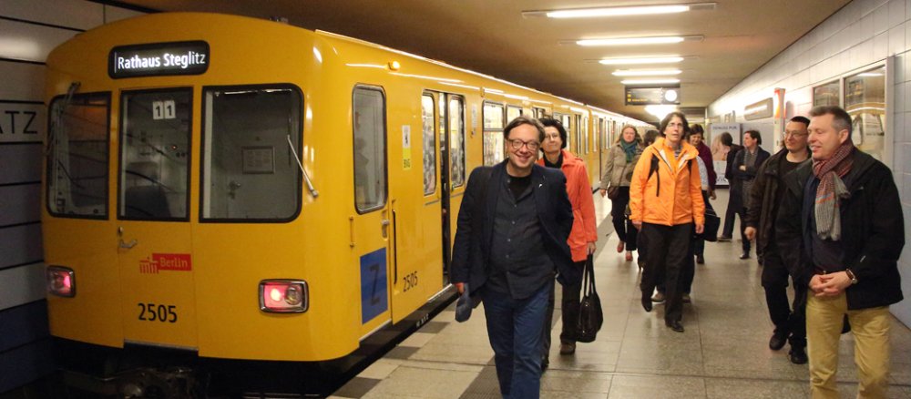 Eine U-Bahn der LInie 19 (am linken Bildrand, gelb) und dutzende Passagiere, die aus dem Zug zu den Ausgängen strömen.