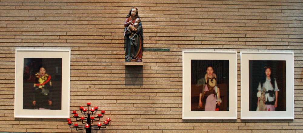 Die Fotos von Kyungwoo Chun hängen neben einer Madonnenskulptur.