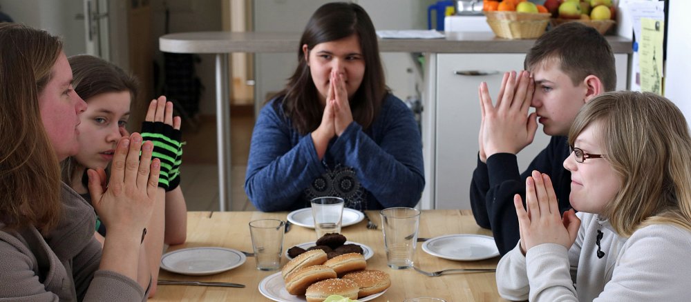 Kinder beten am gedeckten Essenstisch