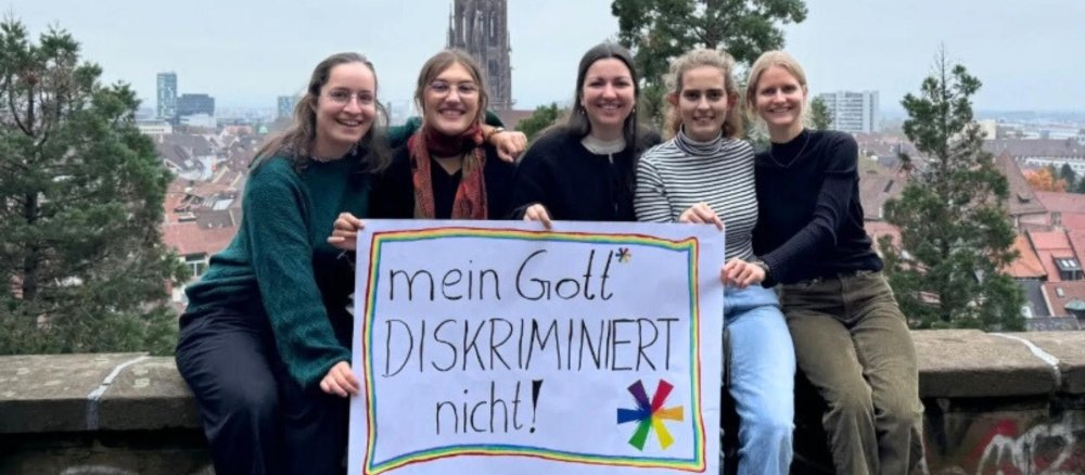 Fünf Frauen halten ein Plakat mit der Aufschrift "Mein Gott diskriminiert nicht"