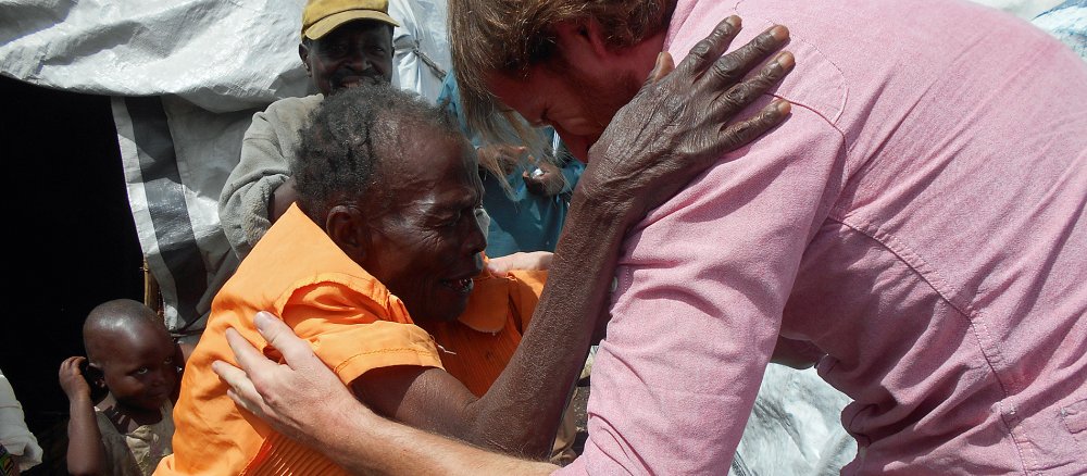 Alte kongolesische Frau und Jesuitenfrater Felix Polten umarmen sich