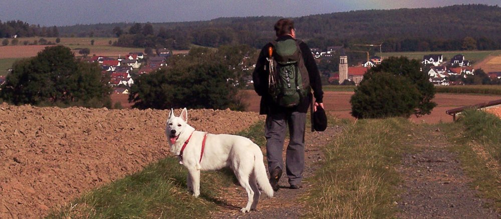 Pfarrer Hans Blamm in Wanderkluft mit seinem weißen Schäferhund "White".