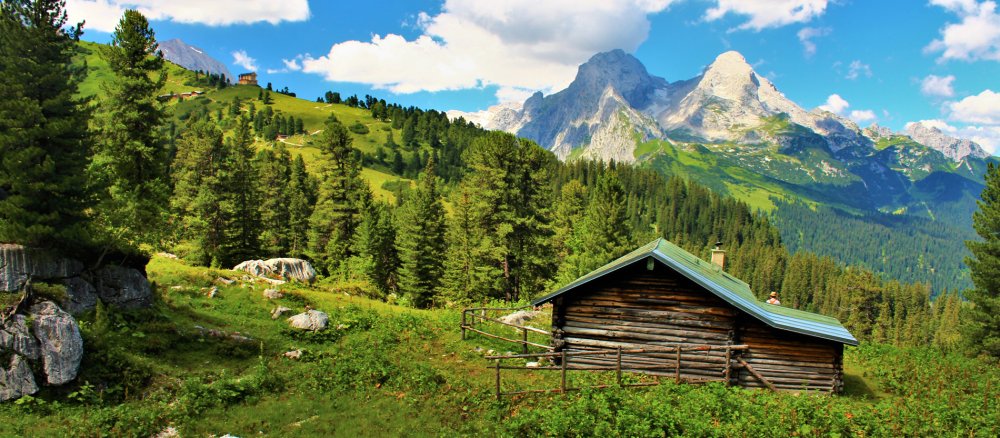 Ein Holzhütte vor dem Alpenpanorama