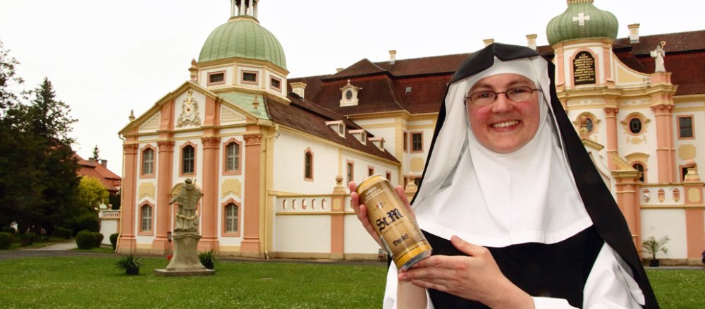 Eine Ordensschwester des Klosters Marienthal hält eine Dose Klosterbier in der Hand.