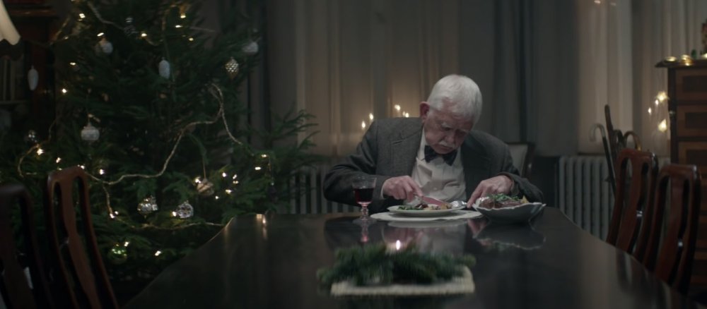 Ein alter Mann sitzt traurig und alleine beim Essen.