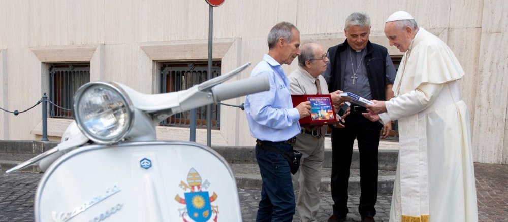 Papst Franziskus bekommt eine weiße Oldtimer-Vespa geschenkt.
